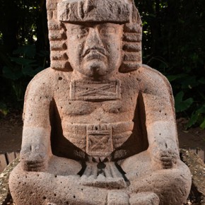 Monument 77 (seated figure wearing cape)
